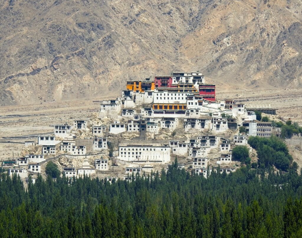 A large white building sitting on top of a lush green hillside
